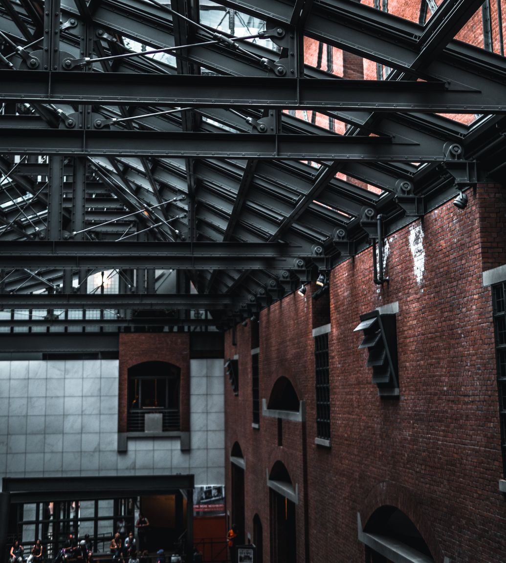 A spacious commercial building featuring a sleek metal roof and numerous windows, housing Versatile A spacious commercial building featuring a sleek metal roof and numerous windows, housing Versatile