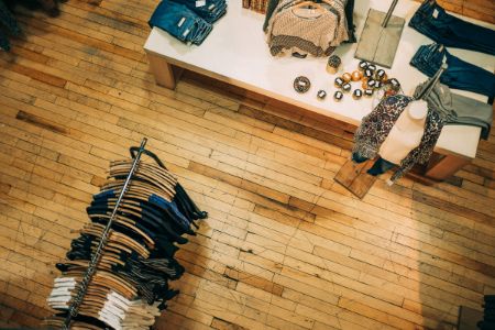 An aerial view of a well-organized clothing store displaying garments scattered on the floor.