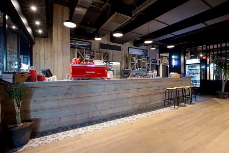 A professional coffee shop featuring polished wooden floors and a sleek counter. A professional coffee shop featuring polished wooden floors and a sleek counter.