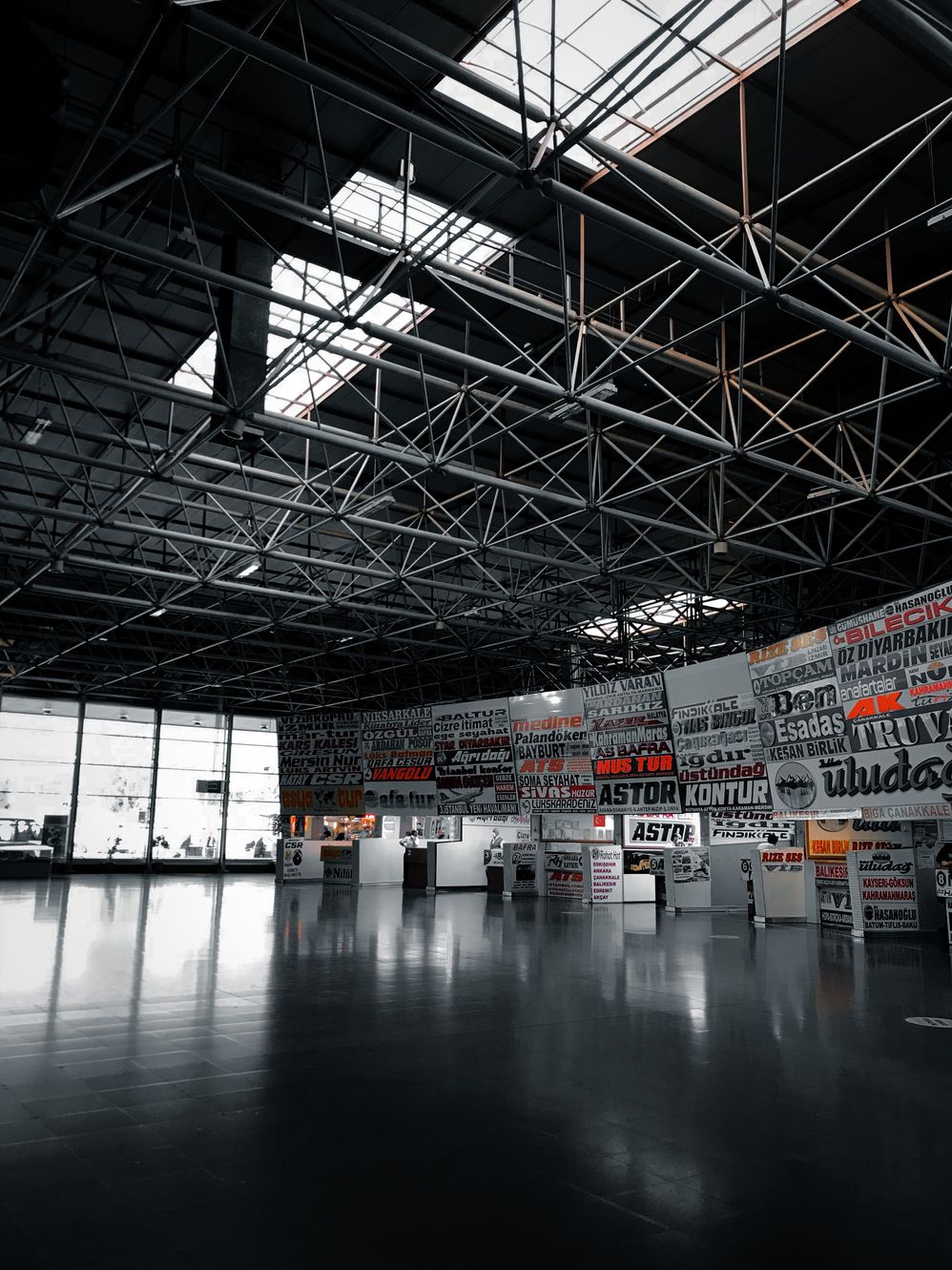 A large, empty warehouse featuring an array of black and white signs placed throughout the space. A large, empty warehouse featuring an array of black and white signs placed throughout the space.