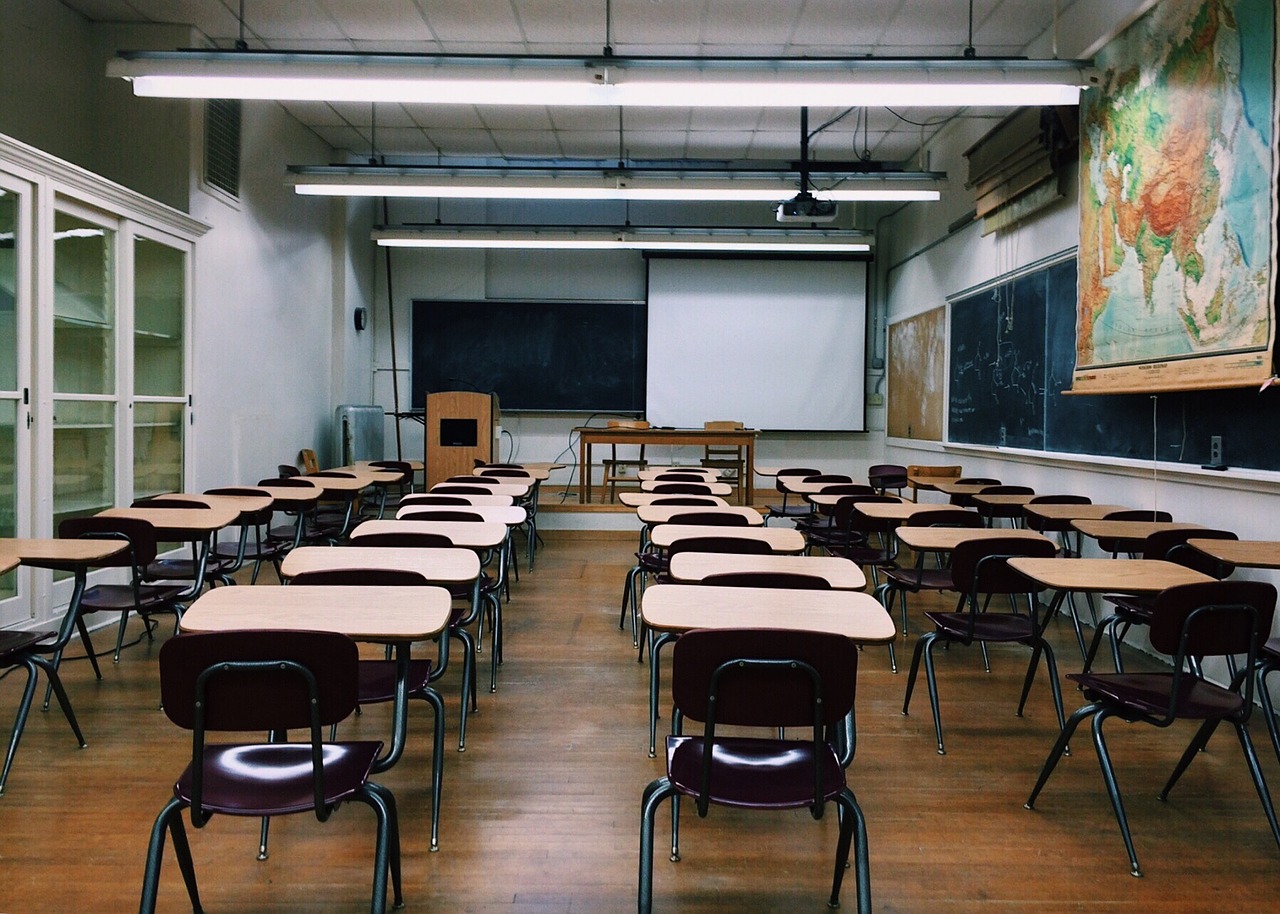 An unoccupied classroom featuring rows of empty desks and chairs, ready to be filled with knowledge and learning. An unoccupied classroom featuring rows of empty desks and chairs, ready to be filled with knowledge and learning.