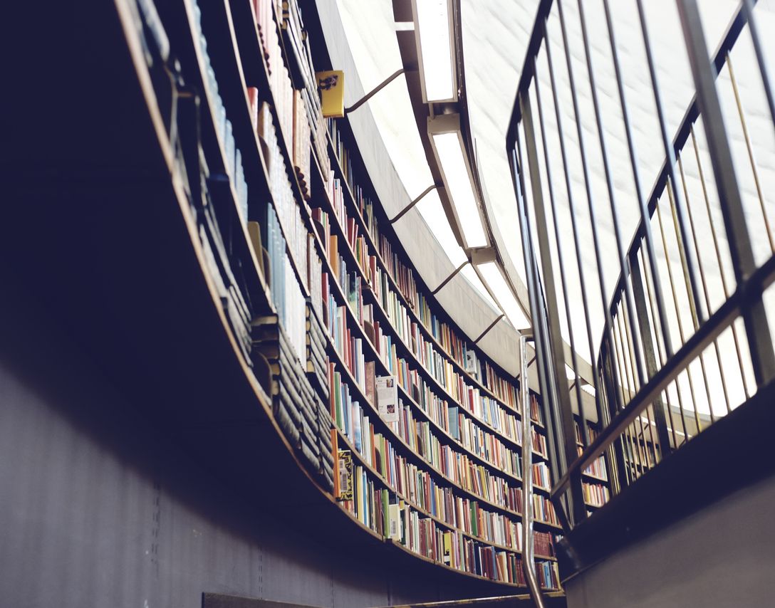 A beautiful spiral staircase in a library, flanked by towering bookshelves, offering a serene and inspiring space for learning and exploration. A beautiful spiral staircase in a library, flanked by towering bookshelves, offering a serene and inspiring space for learning and exploration.