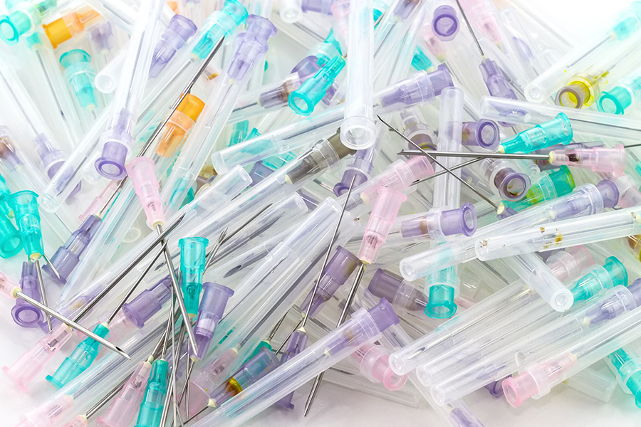 A stack of plastic needles and pins, neatly arranged in a pile, ready for use in various crafting projects. A stack of plastic needles and pins, neatly arranged in a pile, ready for use in various crafting projects.