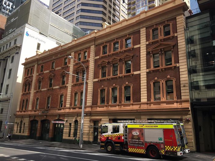 Emergency vehicle parked in front of a building with the words “Fire Department” on the side. Emergency vehicle parked in front of a building with the words "Fire Department" on the side.