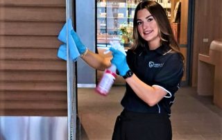Professional janitor with cleaning cart performing commercial cleaning in an office building.