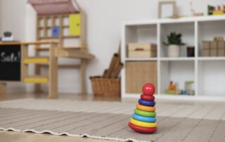 Clean and organised playroom with a colourful toy on a carpet, ensuring a hygienic and safe environment for children.